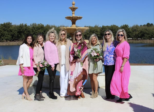 Women in pink posing near fountain at fundraiser