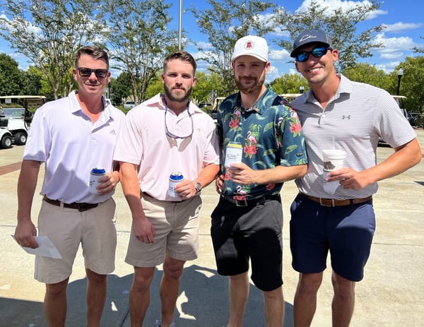 a golf foursome standing in the sun at fundraiser
