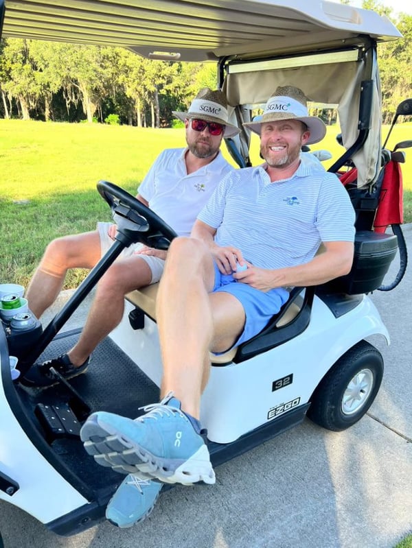 Men in golf cart at fundraiser