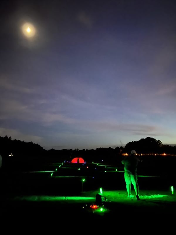 a lighted golf fairway at night for fundraiser